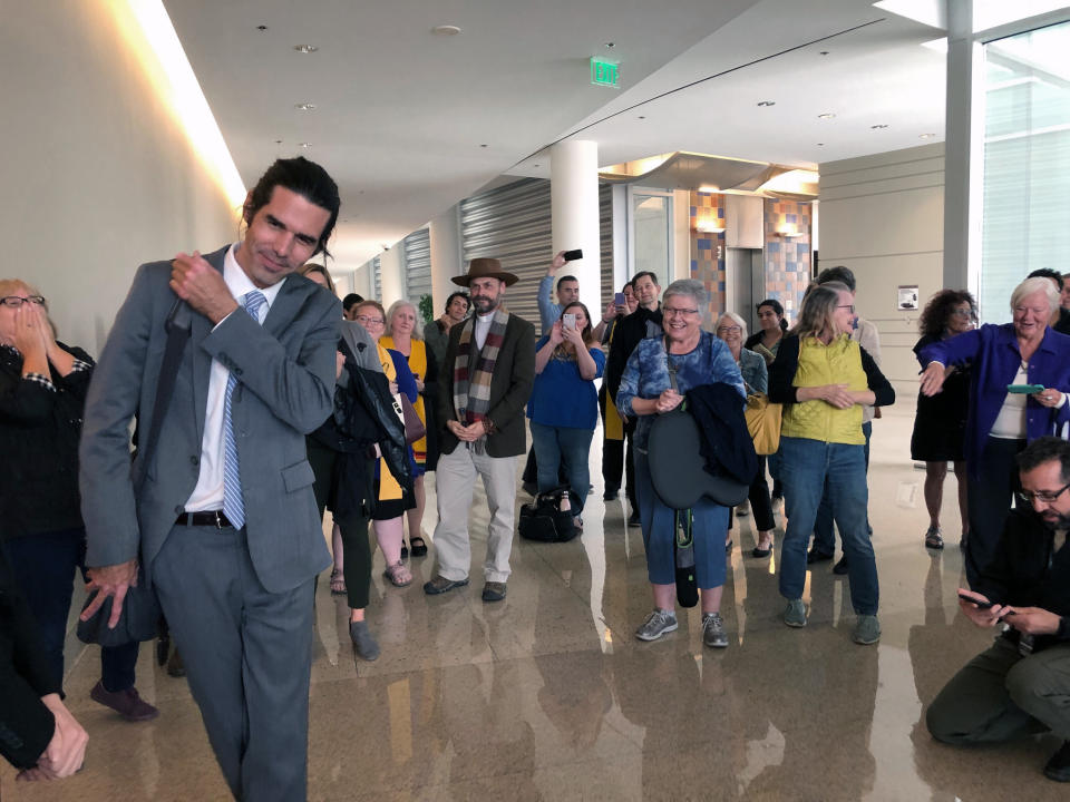 Scott Warren, left, of Ajo, Ariz., thanks his supporters and attorneys after walking out of court in Tucson, Ariz. on Wednesday, Nov. 20, 2019, after being acquitted of two counts of harboring in a case that garnered international attention. Prosecutors said Warren illegally helped two migrants avoid authorities. He said he was fulfilling his humanitarian duties by helping two injured men. (AP Photo/Astrid Galvan)