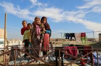 Syrian girls pose for a photo near their house in the Al-Shallal suburb of the northeastern town of Al-Hol in Syria's Hasakeh province, bordering Iraq