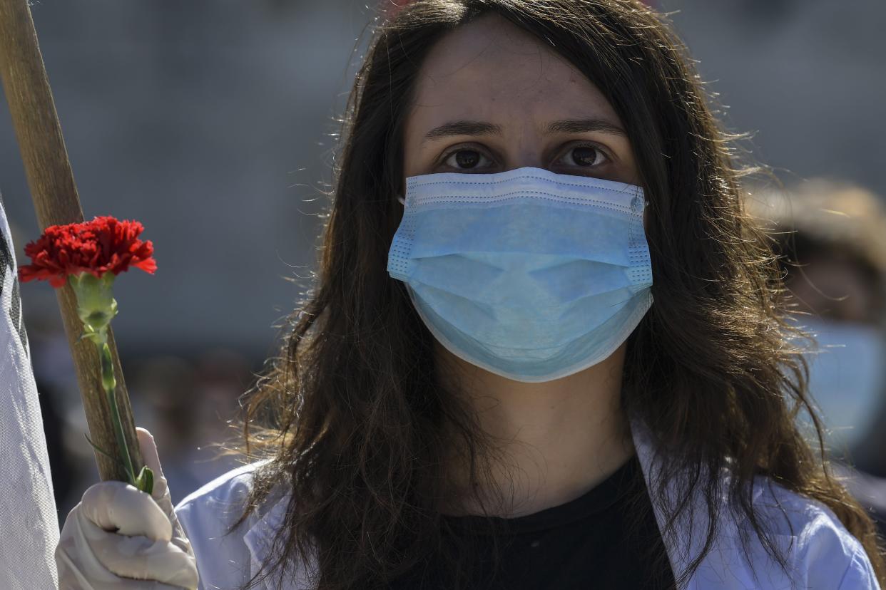 A member of the Greek Labour Union (PAME), holds a red carnation during a protest in front of the Greek Parliament during the Labour Day demonstration in Athens on May 1, 2020, as the Greek government asked unions to delay public rallies by more than a week, but leading union GSEE called for a general strike to coincide with May Day. - Workers were forced to scale back May Day rallies around the world on May 1, 2020, because of coronavirus lockdowns, although some pushed on with online events and others hit the streets in face masks. (Photo by Aris MESSINIS / AFP) (Photo by ARIS MESSINIS/AFP via Getty Images)