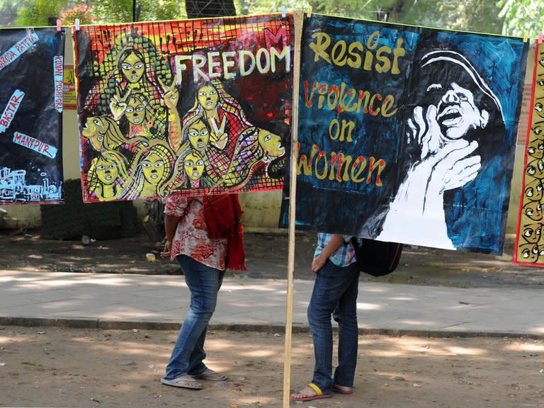 Demonstrators stand behind posters during a protest rally in New Delhi on February 21, 2013