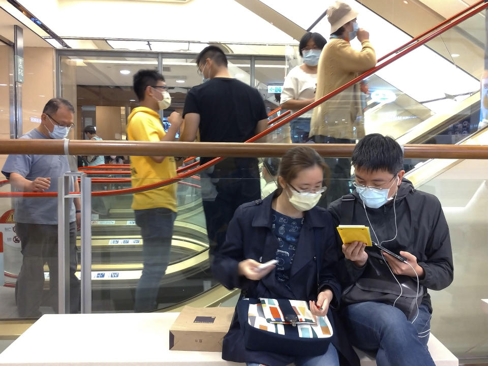 People wear face masks to protect against the spread of the coronavirus at a department store in Taipei, Taiwan, Saturday, March 7, 2020. (AP Photo/Chiang Ying-ying)