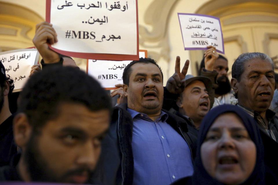 Activists hold up placards that read "No to repression of freedom of expression #MBS assassin" on the eve of Saudi Crown Prince Mohammed bin Salman's official visit to Tunisia, during a protest to denounce the killing of Saudi journalist Jamal Khashoggi, in downtown Tunis, Monday, Nov. 26, 2018. (AP Photo/Hassene Dridi)