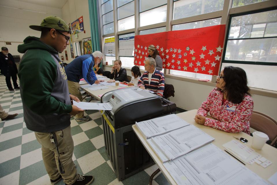 A Hispanic man turns in his ballot at a polling station in Ventura County, California. 