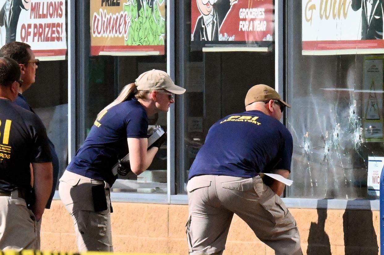 FBI agents look at bullet impacts in a Tops Grocery store in Buffalo, New York, on May 15, 2022, the day after a gunman shot dead 10 people. 