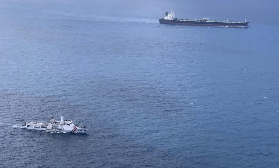 In this undated photo released by Indonesian Maritime Security Agency (BAKAMLA), a BAKAMLA ship escorts Iranian-flagged tanker MT Horse, top right, as they sail towards Batam Island, Indonesia. Indonesian authorities detained the crews MT Horse and Panamanian-flagged MT Freya that were seized Sunday for illegally transferring oil in Indonesian waters, an official said Tuesday. (Indonesian Maritime Security Agency via AP)