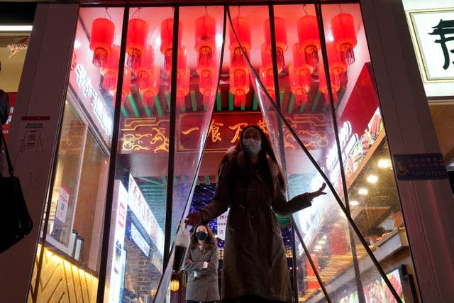 A woman wearing a mask steps out from an eatery in central China’s Hubei province 