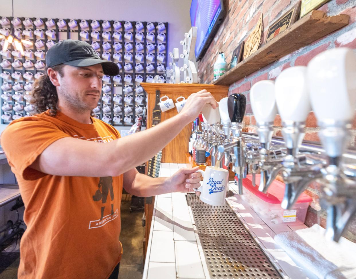 Blake Boccuti pours a beer at the Royal Docks Brewing Co. taproom in Jackson Township. The brewery has announced plans to open a taproom in Cleveland.