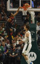 Toronto Raptors' RJ Barrett, left, shoots against Milwaukee Bucks' Brook Lopez, right, during an NBA basketball game Friday, April 5, 2024, in Milwaukee. (AP Photo/Jeffrey Phelps)