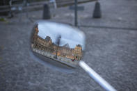 The mostly deserted courtyard of the Louvre Museum which is temporarily closed is seen in a mirror reflection on Saturday, May 2, 2020, in Paris. France continues to be under an extended stay-at-home order until May 11 in an attempt to slow the spread of the COVID-19 pandemic. (AP Photo/Rafael Yahgobzadeh)