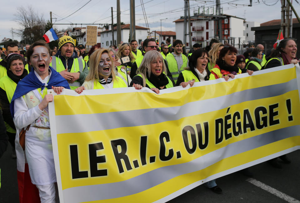 Yellow vest protesters hold a banner reading "Citizenship Referendum Initiative or clear" as they demonstrate in Saint Jean De Luz, France, Saturday, Jan. 19, 2019. Yellow vest protesters are planning rallies in several French cities despite a national debate launched this week by President Emmanuel Macron aimed at assuaging their anger.(AP Photo/Bob Edme)