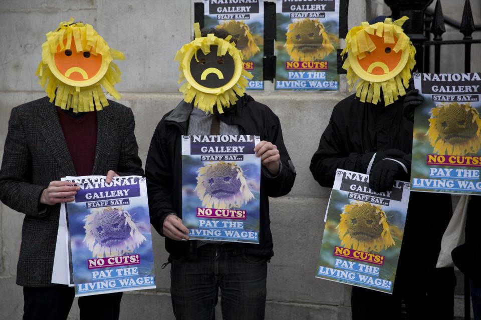 Protesters wearing "Sad Sunflower" masks, who said they are staff at the National Gallery in London, take part in a demonstration against their wage amounts outside the building, Friday, Jan. 24, 2014. They held the protest Friday to coincide with the opening of a new Vincent van Gogh Sunflowers exhibition. (AP Photo/Matt Dunham)