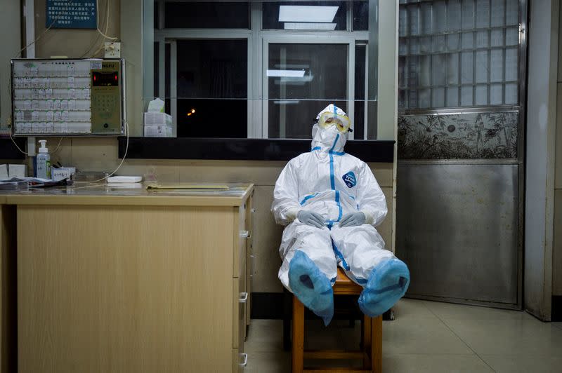FOTO DE ARCHIVO: Una trabajadora sanitaria en traje de protección toma un descanso durante su turno de noche en un centro de servicios de salud de la comunidad, que tiene una sección aislada para recibir pacientes con síntomas leves causados por el nuevo coronavirus y pacientes sospechosos del virus, en el distrito Qingshan de Wuhan, provincia de Hubei, China