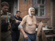 FILE - A paramedic helps a man wounded by the Russian shelling to leave his house in Slovyansk, Donetsk region, Ukraine, Thursday, June 30, 2022. (AP Photo/Efrem Lukatsky, File)