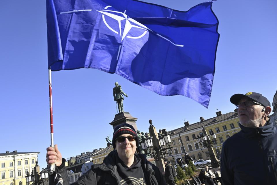 Eemeli, with the Nato flag, and Matt Jarvelainen celebrate the Finnish Nato membership at the Senate Square in Helsinki, Finland, on April 4, 2023. Earlier today Finland became the 31st member state of The North Atlantic Treaty Organization NATO. (Markku Ulander/Lehtikuva via AP)