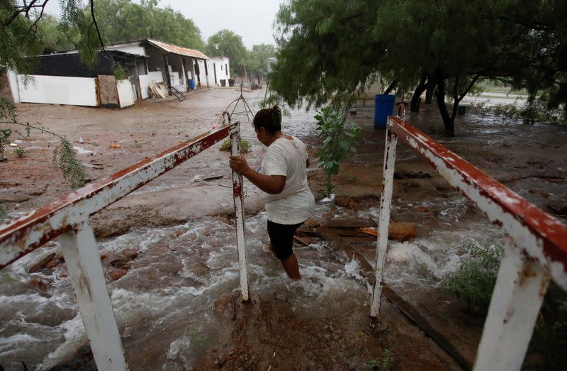 Concepción Cruz, familiar de uno de los mineros atrapados en una mina de carbón que colapsó, cruza una corriente de agua extraída de la mina, en Sabinas, estado de Coahuila, México