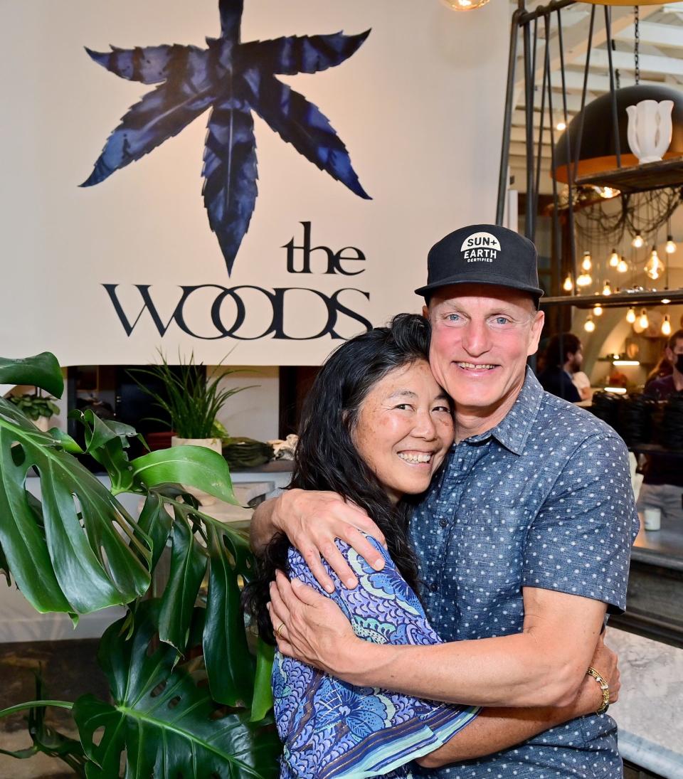 <p>Laura Louie and Woody Harrelson share a hug at opening day of The Woods in West Hollywood on May 13.</p>