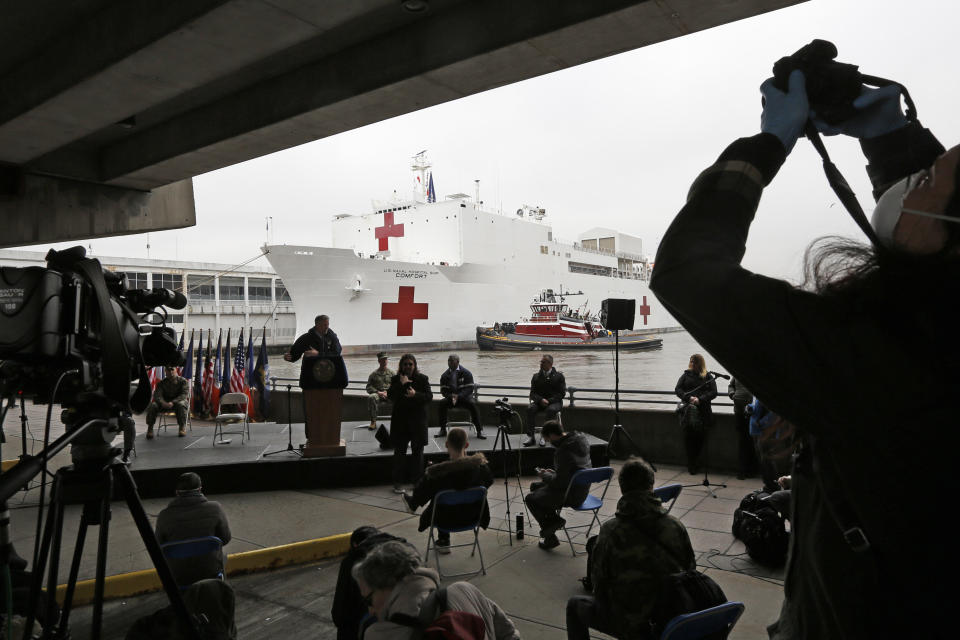 A journalist records speakers at a press briefing following the arrival of the USNS Comfort, a naval hospital ship with a 1,000 bed-capacity, March 30, 2020, at Pier 90 in New York. The ship will be used to treat patients who do not have the new coronavirus as land-based hospitals fill up to capacity with those that do. (AP Photo/Kathy Willens)