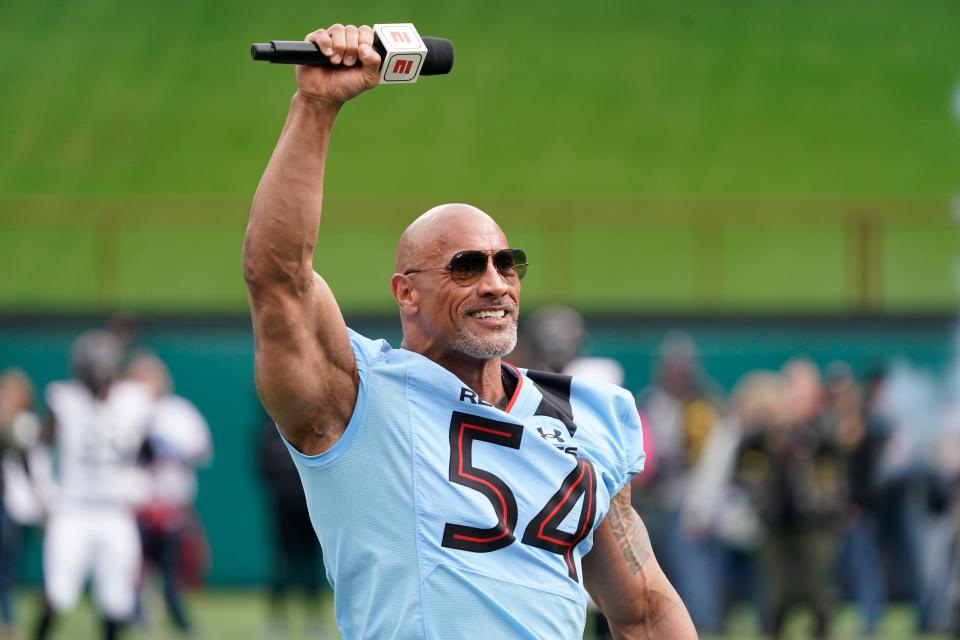 XFL owner Dwayne Johnson talks on the field prior to Saturday's game between the Arlington Renegades and Vegas Vipers at Choctaw Stadium in Arlington, Texas.