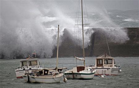 Waves crash over the breakwater of Saint Evette harbour at Esquibien in Brittany as an Atlantic storm hits western France, December 23, 2013. REUTERS/Mal Langsdon