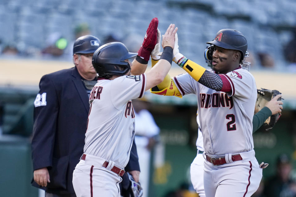 Arizona Diamondbacks' Geraldo Perdomo, right, celebrates with Dominic Fletcher, front left, after hitting a two-run home run against the Oakland Athletics during the second inning of a baseball game in Oakland, Calif., Monday, May 15, 2023. (AP Photo/Godofredo A. Vásquez)