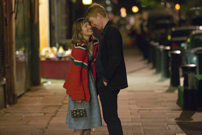 Rachel McAdams and Domhnall Gleeson laughing in the street together in about time