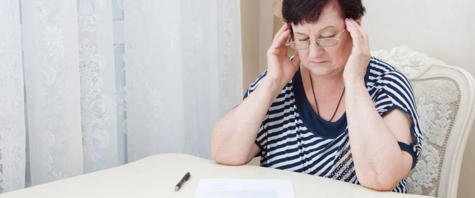 Attractive Old Woman, Read the Paper and count the Money. Portrait  Pensioner Concern about Payments and Payment of bills, large Taxes, Social Assistance and Labor Exchange.