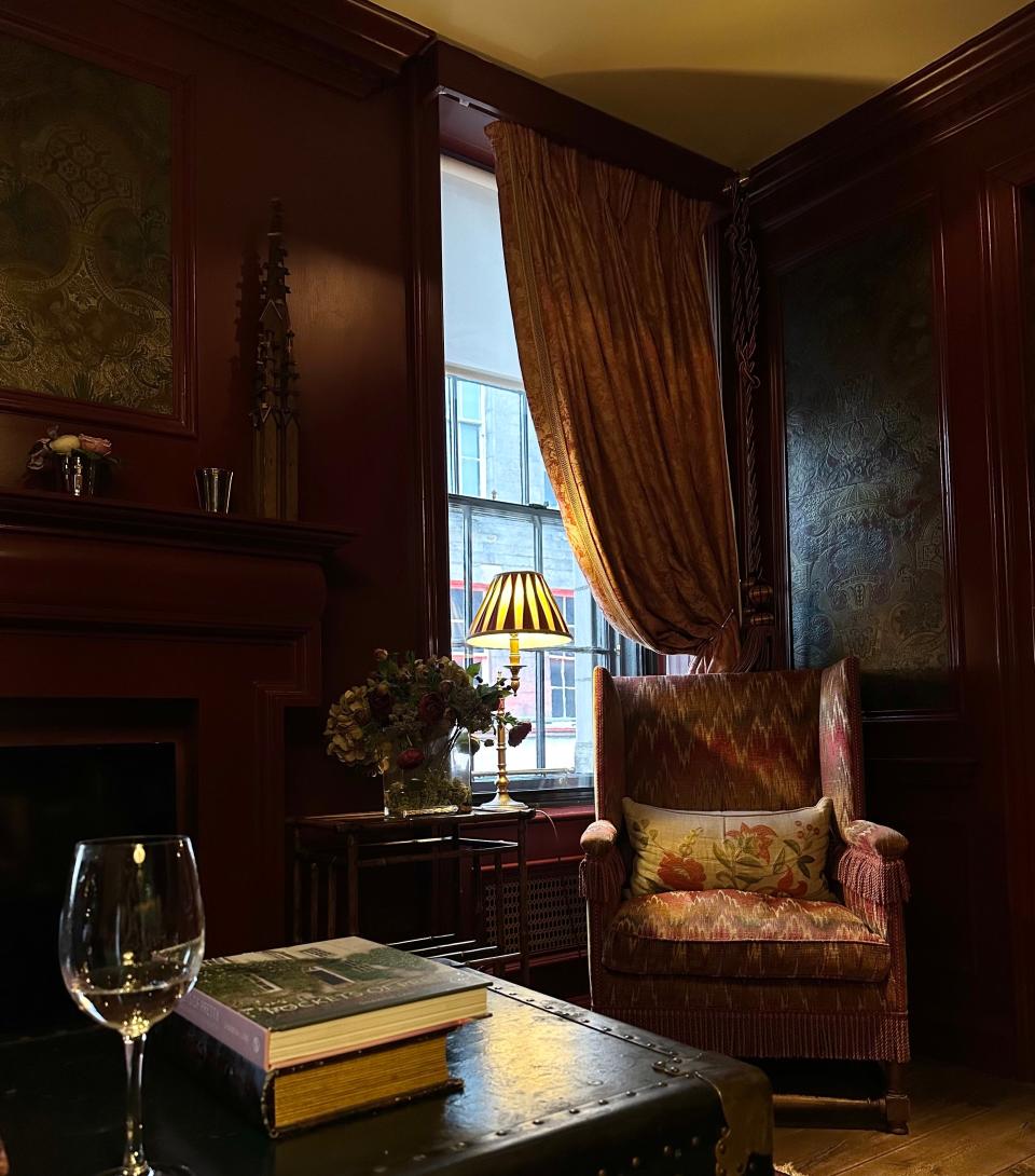 A dark red interior living room with red accent furniture and trunk coffee table.