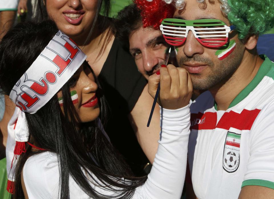 An Iran supporter applies face paint to another fan before the Asian Cup Group C soccer match betweeen Iran and Bahrain at the Rectangular stadium in Melbourne