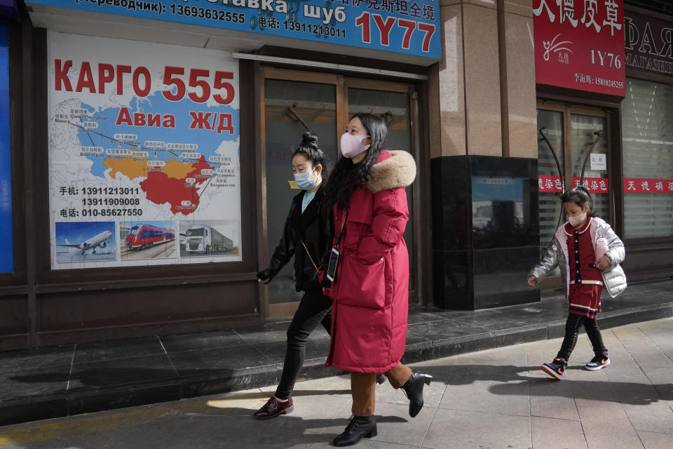 Residents past near shops at a mall, also known as Russia Market, for Russian traders on Saturday, Feb. 26, 2022, in Beijing. China is the only friend that might help Russia blunt the impact of economic sanctions over its invasion of Ukraine, but President Xi Jinping's government is giving no sign it might be willing to risk its own access to U.S. and European markets by doing too much. (AP Photo/Ng Han Guan)