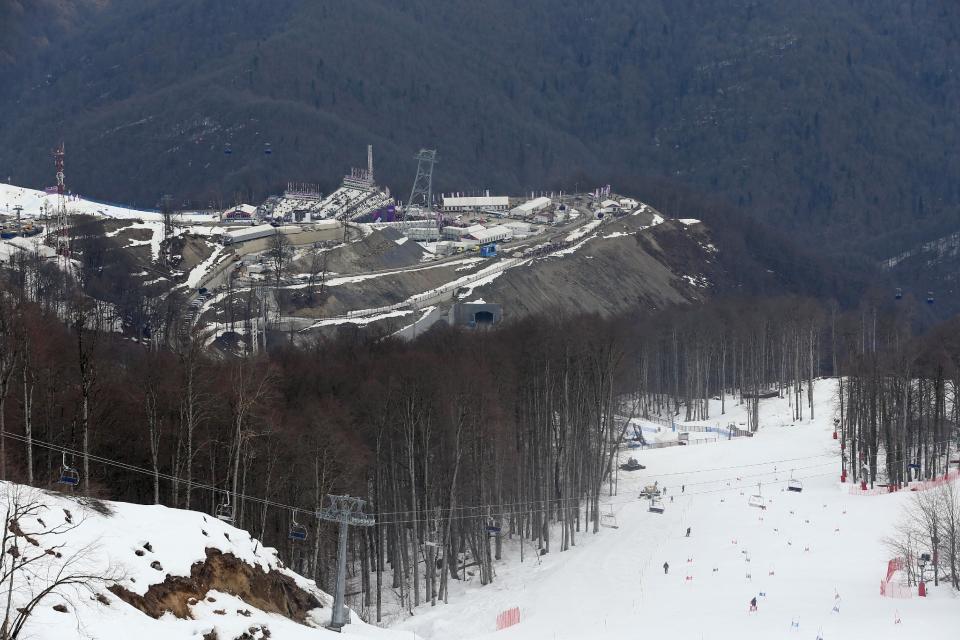 A view from near the alpine course showing the difference between the snow covered piste and the snowless lower slopes at the Sochi 2014 Winter Olympics, Tuesday, Feb. 11, 2014, in Krasnaya Polyana, Russia. Warm temperatures in the mountains made the snow too soft and caused the cancellation of women's downhill training on Tuesday. (AP Photo/Luca Bruno)