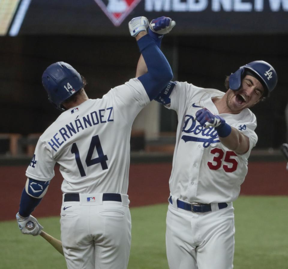 Cody Bellinger does a forearm slam with teammate Kiké Hernández.