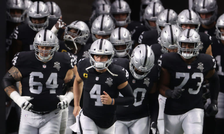 Las Vegas Raiders including Derek Carr and Maurice Hurst run onto the field.