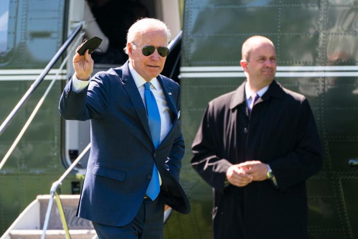 President Joe Biden waves as he walks past a Secret Service agent upon arrival at the White House from a weekend trip to his Delaware home, on Monday in Washington.