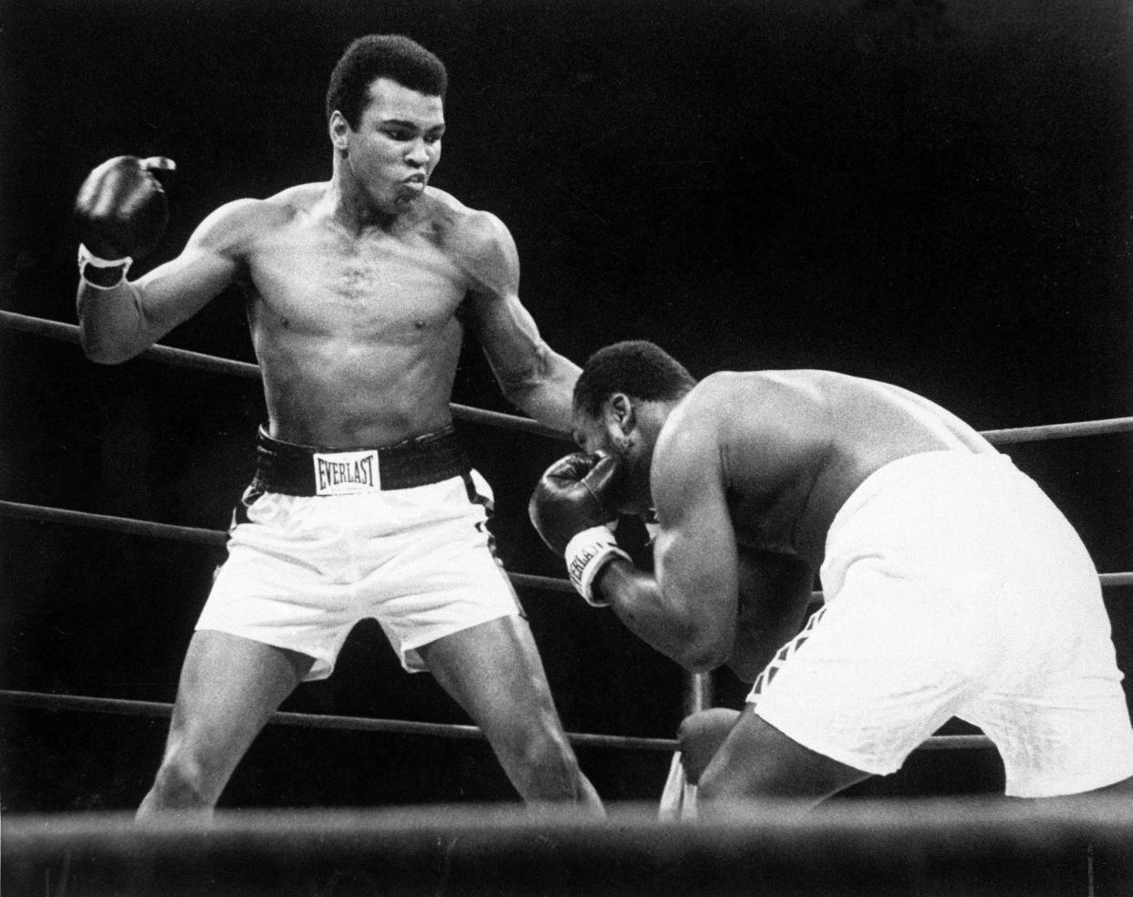 ** FILE ** Muhammad Ali throws a punch at Joe Frazier, right, during their bout at Madison Square Garden in New York, Jan. 28, 1974. Ali's hometown of Louisville is ready to unveil a museum celebrating the life of one of the 20th century's most recognizable figures. The Muhammad Ali Center is to open Nov. 21,2005, chronicling the life of "The Greatest" inside and outside the ring, emphasizing his peaceful values and vision of global tolerance, and setting the record straight about that infamous gold medal. (AP Photo/File)