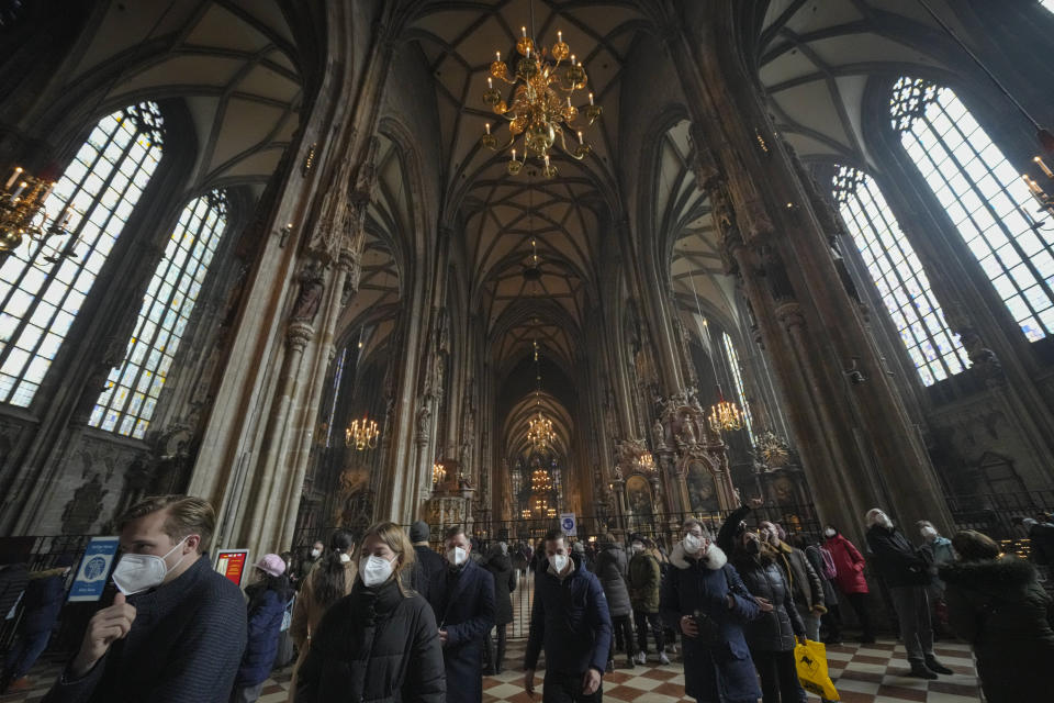 People wearing face masks visit the St. Stephen's Cathedral in Vienna, Austria, Sunday, Nov. 21, 2021. The Austrian government announced a nationwide lockdown that will start Monday and comes as average daily deaths have tripled in recent weeks and hospitals in heavily hit states have warned that intensive care units are reaching capacity.(AP Photo/Vadim Ghirda)