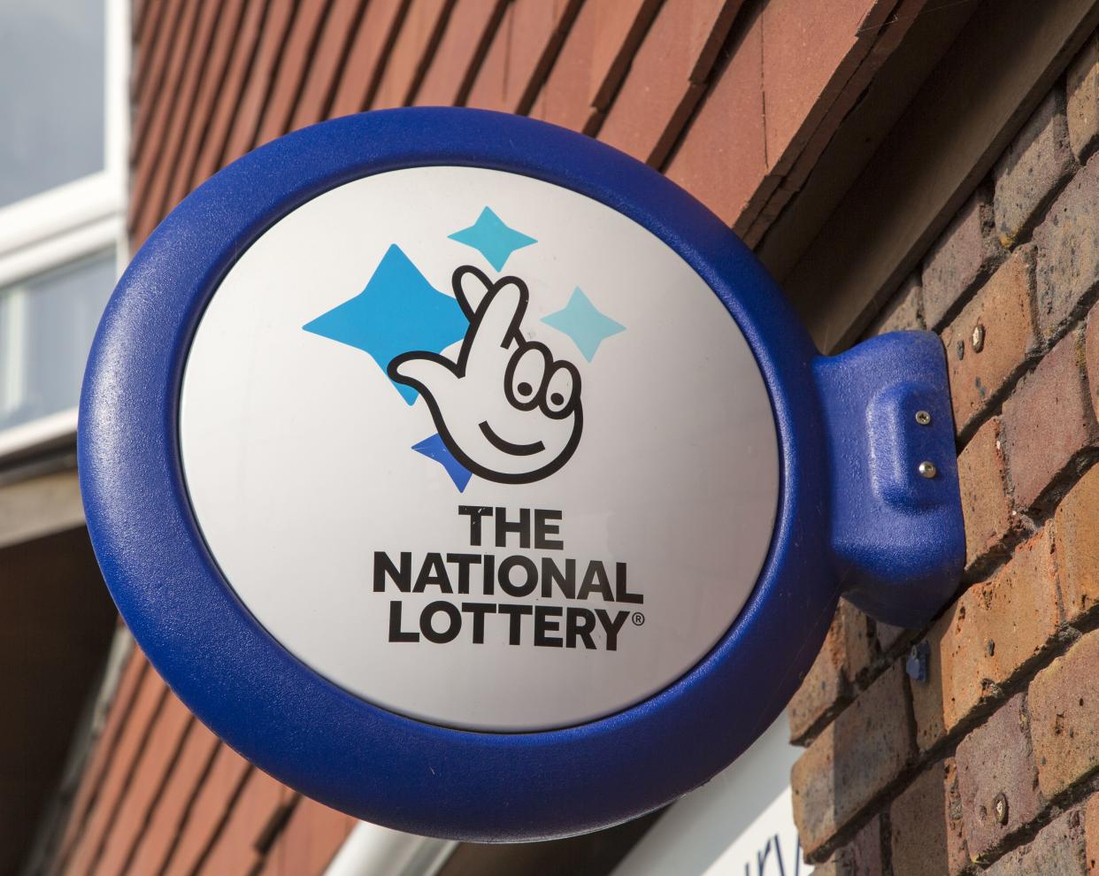 Wall mounted sign for the National Lottery, Amesbury, Wiltshire, England, UK. (Photo by: Geography Photos/Universal Images Group via Getty Images)