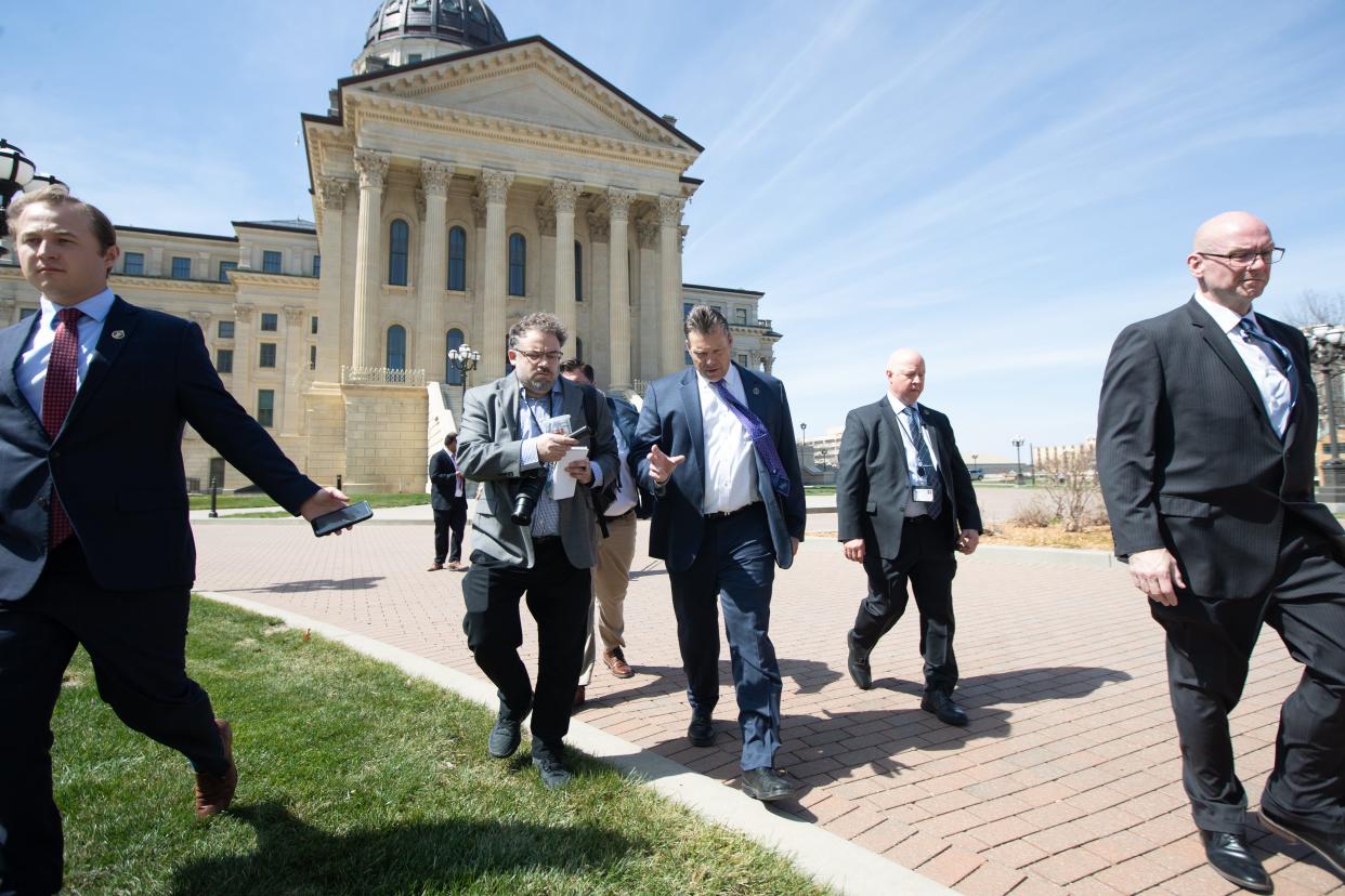 Kansas Attorney General Kris Kobach answers questions from the media as he walks out of a news conference where he discussed a lawsuit his office is filing against the Biden administration regarding student loan debt forgiveness.