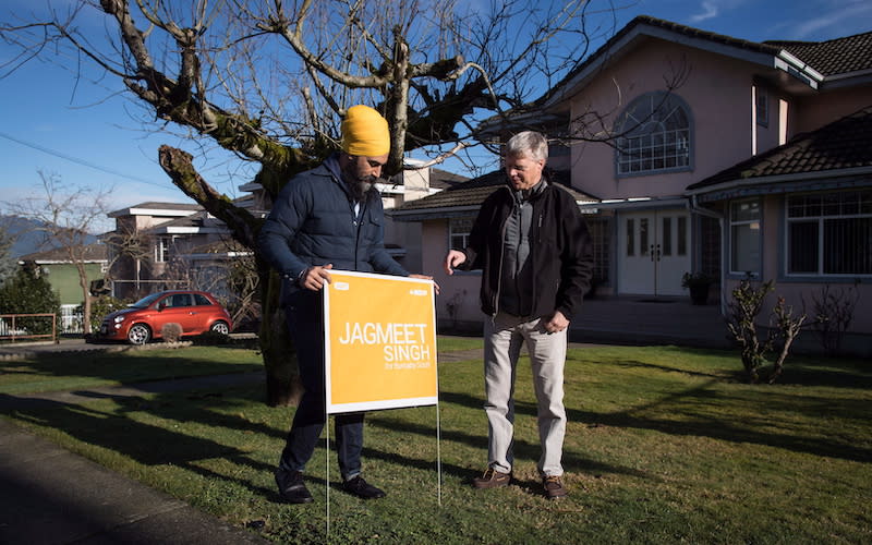 NDP Leader Jagmeet Singh, left, places a sign on a lawn in Burnaby, B.C., in January 2019. Singh is trying to win the Burnaby South riding that was last held by former NDP MP Kennedy Stewart. Photo from The Canadian Press.