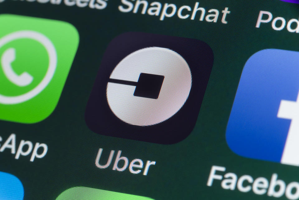 London, UK - July 30, 2018: The buttons of the taxi App Uber, surrounded by WhatsApp, Facebook, Snapchat and other apps on the screen of an iPhone.