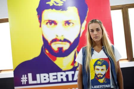 Lilian Tintori, wife of jailed Venezuelan opposition leader Leopoldo Lopez, poses for a picture in front of a poster depicting her husband at the office of the party Popular Will (Voluntad Popular) in Caracas, Venezuela January 18, 2017. REUTERS/Carlos Garcia Rawlins