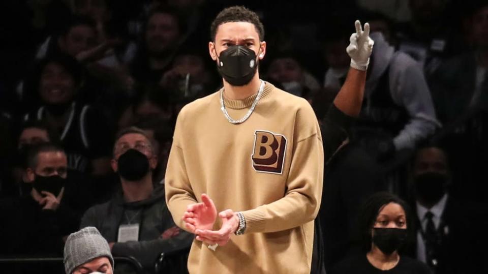 Ben Simmons clapping in street clothes wearing mask