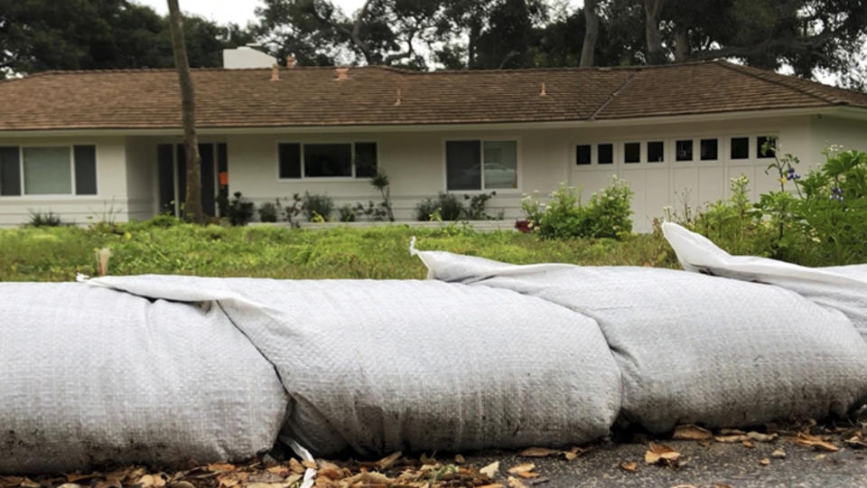 This photo provided by KEYT-TV shows sandbags protecting a home in Montecito, Calif., Tuesday, March 5, 2019. The Santa Barbara County Sheriff's Office on Tuesday ordered about 3,000 residents to evacuate ahead of a new storm expected to hit areas scarred by wildfires, including parts of Montecito hit by a disastrous debris flow just over a year ago. Residents of risk areas below the Thomas, Whittier and Sherpa fire burn scars were told to leave their homes by 4 p.m. (John Palminteri/KEYT-TV via AP)
