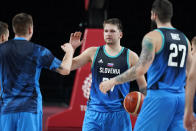 Slovenia's Luka Doncic celebrates with teammates at the end of a men's basketball preliminary round game against Spain at the 2020 Summer Olympics, Sunday, Aug. 1, 2021, in Saitama, Japan. (AP Photo/Charlie Neibergall)