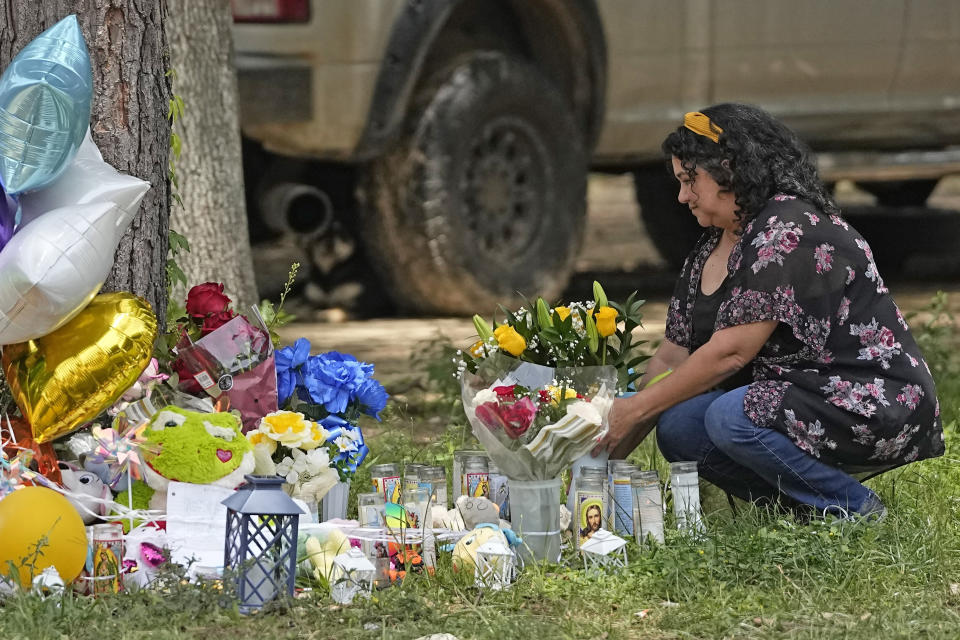 Maria Rodriguez places flowers Tuesday, May 2, 2023, outside the home where a mass shooting occurred Friday, in Cleveland, Texas. The search for the suspected gunman who allegedly shot five of his neighbors, including a child, after they asked him to stop firing off rounds in his yard stretched into a fourth day Tuesday. (AP Photo/David J. Phillip)