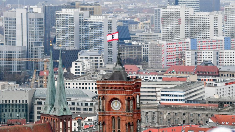 Hinter den Türmen der Marienkirche (l) und des Roten Rathauses sind zahlreiche Wohnblocks zu sehen.