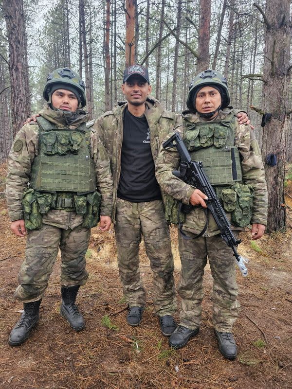 Hemil Mangukiya, middle, poses for a photograph with two other men in military uniform