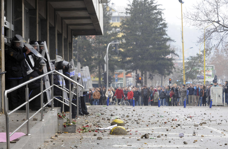 Bosnian police forces secure the entrance as protesters stoned a local government building in the Bosnian town of Tuzla, 140 kms north of Sarajevo, Thursday, Feb. 6, 2014. Several hundred protesters clashed with police as they tried to storm into the building of the local government and confront the officials there whom they blame for allowing the city's major state-owned companies to go bankrupt after dubious privatizations. (AP Photo/Darko Zabus)