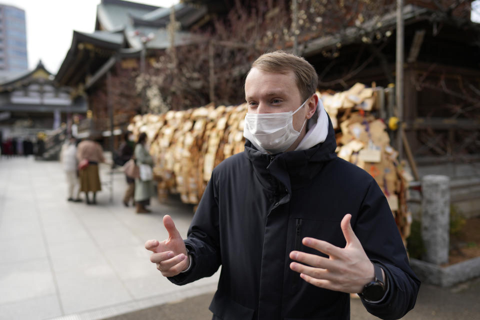 Ukrainian Dmytro Remez speaks to a reporter as he visits the Yushima Tenjin shrine on Feb. 15, 2023 in Tokyo, Japan. Remez, 24, a fledgling medical doctor studying at Juntendo University, is among the 2,291 Ukrainians who have moved to Japan since the war with Russia began a year ago. (AP Photo/Shuji Kajiyama)