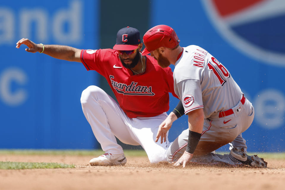 Cleveland Guardians' Amed Rosario tags out Cincinnati Reds' Colin Moran (16) for the second out of a double play on a ball hit by Kyle Farmer during the fifth inning of a baseball game, Thursday, May 19, 2022, in Cleveland. (AP Photo/Ron Schwane)