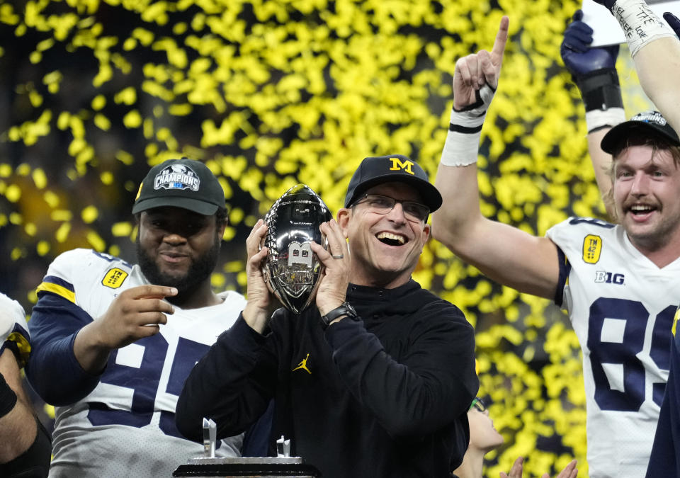 FILE - Michigan coach Jim Harbaugh celebrates with the team after the Big Ten championship NCAA college football game against Iowa, Saturday, Dec. 4, 2021, in Indianapolis. Michigan won 42-3. Harbaugh is The Associated Press college football coach of the year after leading the Wolverines to their first Big Ten title in 17 years and a berth in the College Football Playoff. (AP Photo/AJ Mast, File)